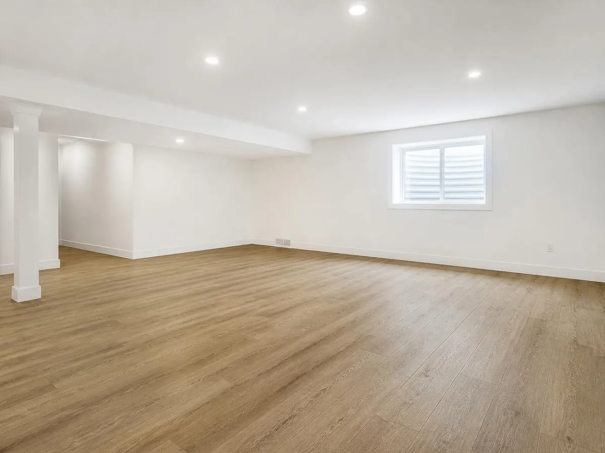 A basement family room with new oak-look vinyl plank flooring